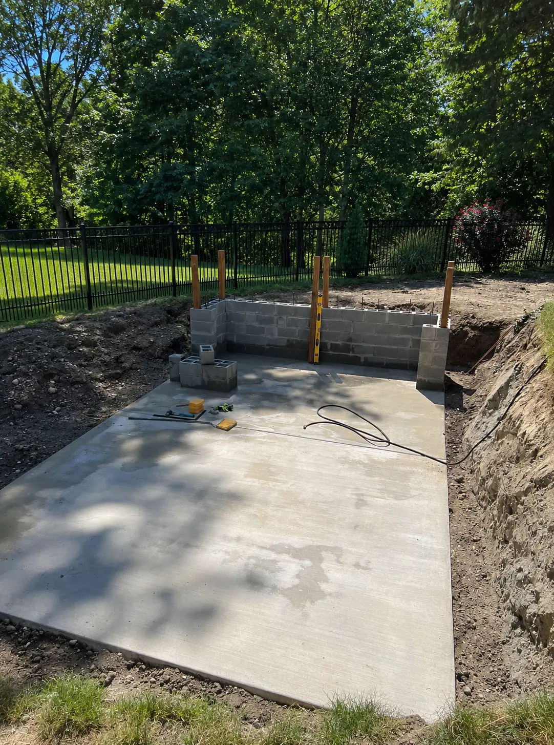 Concrete foundation pad and block walls prepared for a container pool in a Texas backyard